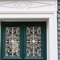 Haustür - obere Hälfte mit einem schnörkelig vergitterten Fenster